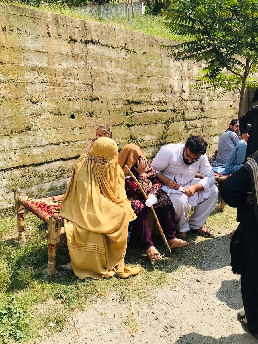 A volunteer doctor consulting with a patient at a camp