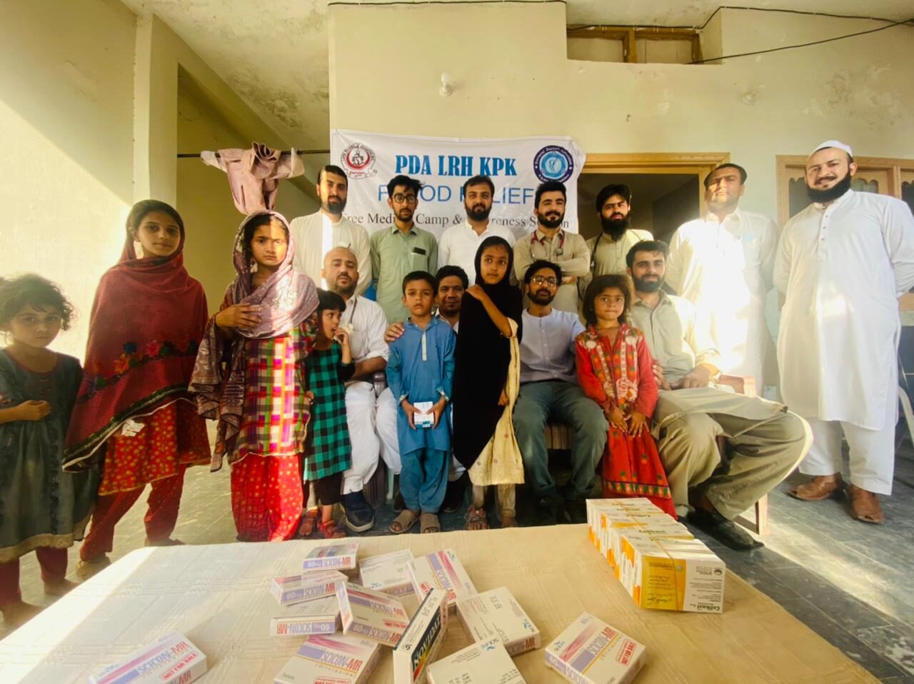 Families gathering around a medical supplies table