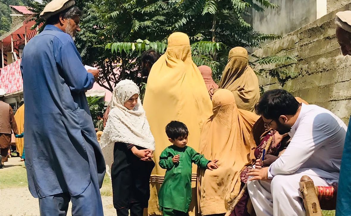 A volunteer doctor examining a patient during a Sehat Sitara medical relief camp